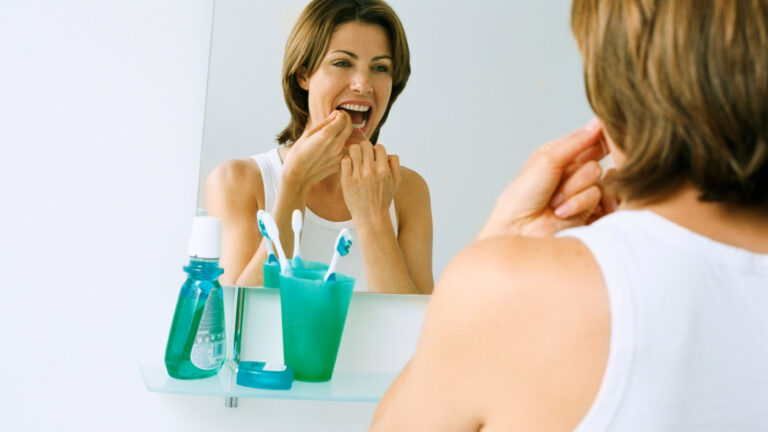 Woman doing a deep dental cleaning with dental floss